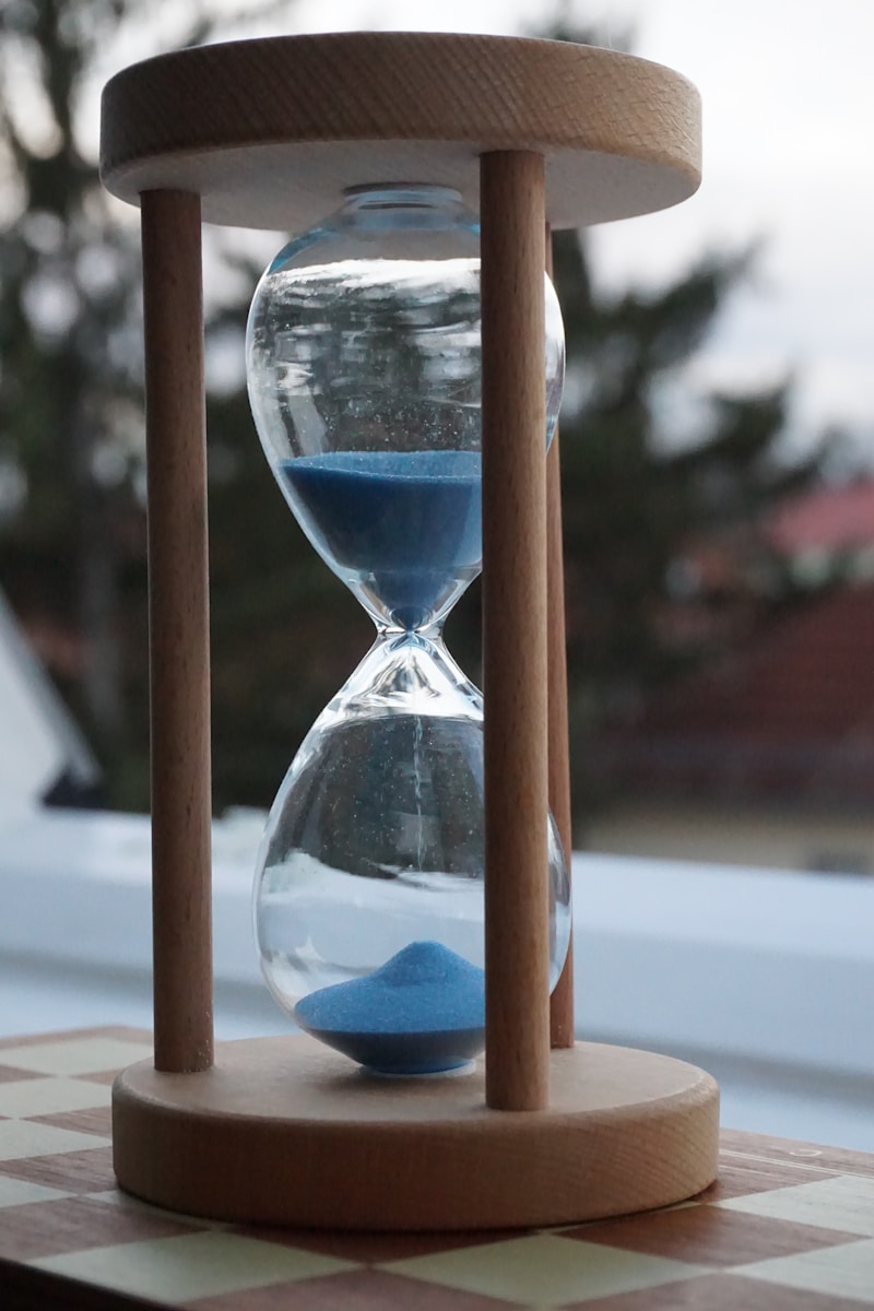 an hourglass sitting on top of a checkered table